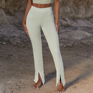Gros plan du pantalon évasé taille haute avec fente latérale et tissu vert sauge drapé
