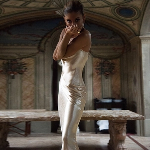 Close-up of champagne gold satin backless dress with a luxurious silk-like drape and texture