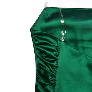 Détail d'une robe en satin vert foncé avec fronces latérales et bretelles transparentes