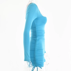 Detail view of light blue bodycon jumpsuit featuring side ruching and long sleeves