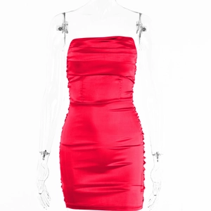 Détail d'une mini-robe bustier en satin rouge vif à volants et coupe moulante