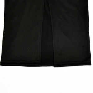 Detail view of the front slit hem on a black bodycon dress with precise stitching
