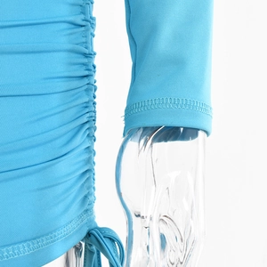 Detail of sky blue knit romper showing side ruching with adjustable drawstrings and flat seams