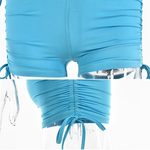 Detail view of sky blue ribbed athletic rompers featuring side drawstrings and ruching