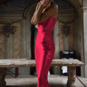Side view of elegant red satin backless dress showing a sleek fit and lustrous texture