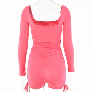 Detail view of pink long sleeve romper featuring backless design and ruched fabric texture