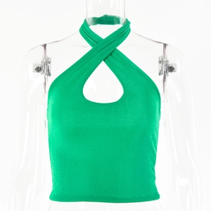 Detail of light green ribbed knit crop top featuring a criss-cross halter neck design