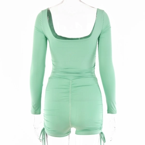 Detail of mint green long sleeve romper featuring deep U-shape backless design and ruched butt