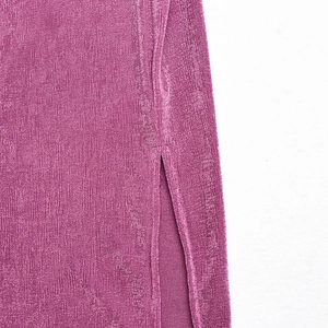 Gros plan détaillé du tissu en maille violette avec fente latérale et texture côtelée