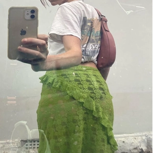 Close-up of bright green floral lace skirt featuring ruffle details and sheer texture