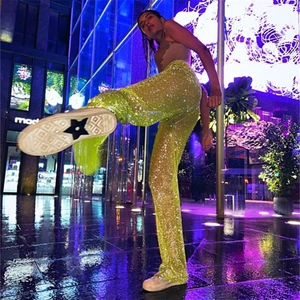 Détail du pantalon à paillettes vert néon avec strass brillants pour tenue de soirée
