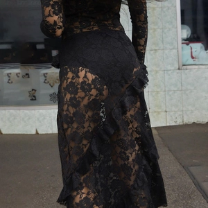 Detail of sheer black lace maxi skirt showing floral patterns and ruffled layers