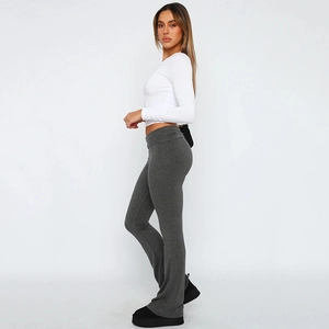 Detail view of high waisted flared yoga pants and white cropped top for a slim fitness look