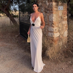 Detail of elegant V-neck backless ivory chiffon maxi dress with a black 3D flower accent