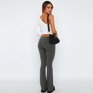 Detail of high waisted flared trousers and white one-shoulder top on fashion model