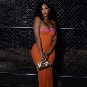 Détail d'une robe moulante orange avec dentelle rose et pochette dorée élégante