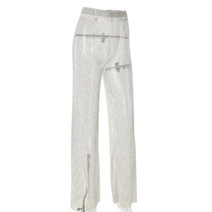 Détail du pantalon en maille argentée avec strass brillants et texture à paillettes ajourée