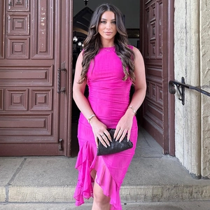 Détail de la robe midi sans manches rose fuchsia avec volants élégants et plissés
