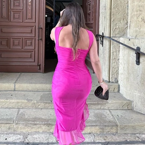 Détail du dos nu et du design plissé de cette robe midi de couleur fuchsia éclatant