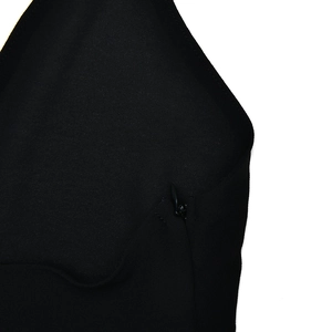 Close-up detail of smooth black fabric texture and small invisible zipper closure on dress