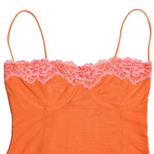 Détail du corsage en dentelle orange avec bordure rose et fines bretelles