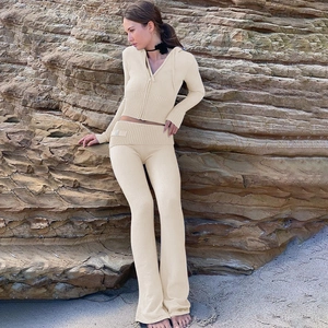 Detail of beige knitted hooded top and high-waisted flared trousers with ribbed waistband