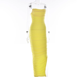 Detail of yellow ruched bodycon maxi dress featuring high slit and stretchy fabric