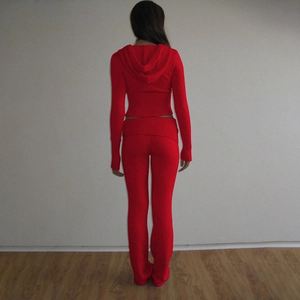 Back view of red knitted two-piece set featuring hooded crop top and flare pants