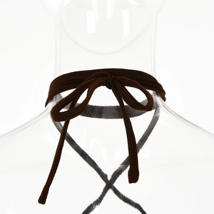 Close-up of dark brown ribbed knit neck tie detail with a delicate bow knot style