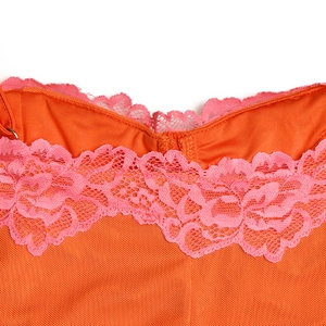 Détail de la bordure en dentelle florale sur la robe orange avec texture en maille fine et broderie