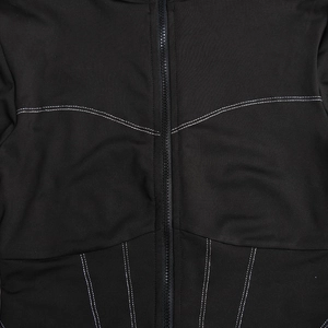 Detailaufnahme eines schwarzen Bodysuits mit weißen Kontrastnähten und vorderem Reißverschluss