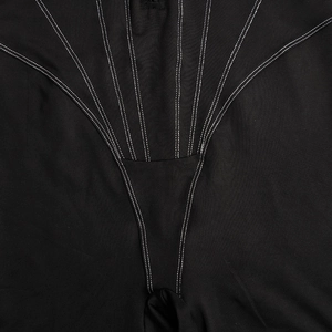 Detailaufnahme des schwarzen Jumpsuits mit weißen Kontrastnähten und Stofftextur