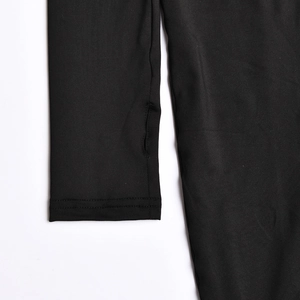 Detail eines schwarzen langärmeligen Overalls mit Daumenloch-Manschette und Doppelnaht