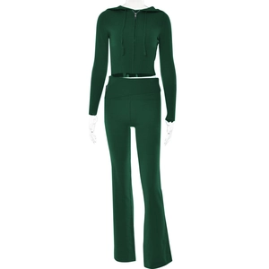 Detailed texture of dark green ribbed knit fabric on a hooded top and flare pants set