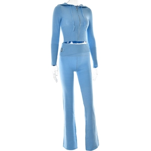 Detail of light blue knitted hoodie set featuring metal buckle on high waist flared pants