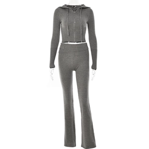 Detail of grey knitted two-piece set showing ribbed waistband and smooth zipper texture