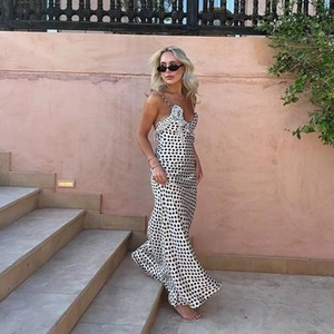 Detail of V-neck lace trim and black polka dots on white satin long dress