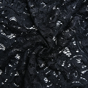 Dettaglio di intricati motivi in pizzo nero con ricami floreali e trama a rete