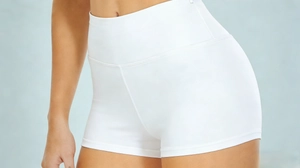Detail of high-waisted white yoga shorts showing premium elastic fabric and stitching