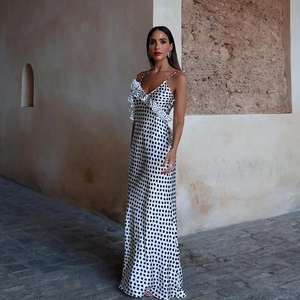 Close-up of white satin polka dot dress featuring V-neckline with ruffle trim details