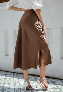 Detail view of smooth satin midi skirt in brown featuring a stylish side slit and fabric texture