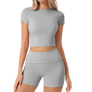 Dettaglio del set sportivo grigio con top corto a maniche corte e pantaloncini da yoga
