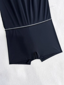 Detailed macro view of the black mini skirt shorts fabric with white elastic piping and size S label