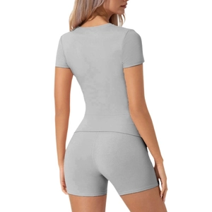Vista posteriore del set sportivo grigio due pezzi con pantaloncini a vita alta e top
