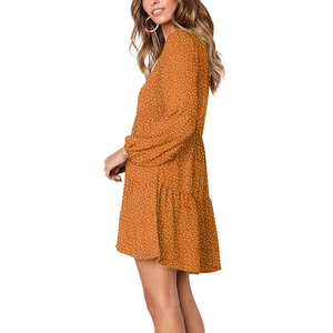 Detail view of orange polka dot long sleeve dress with tiered ruffle hem and elastic cuffs