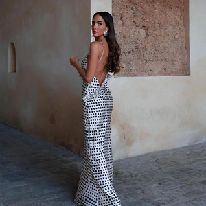 Detail of a backless polka dot satin maxi dress showing the low back and slim fit silhouette