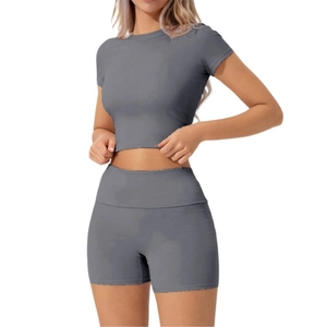 Dettaglio del crop top grigio a maniche corte e pantaloncini sportivi a vita alta