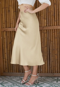 Elegant champagne satin midi skirt with side slit and smooth texture on a female model