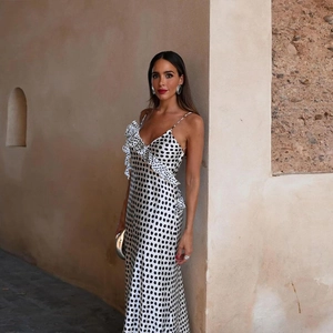 Detail of satin polka dot maxi dress with ruffled shoulder and slim fit silhouette