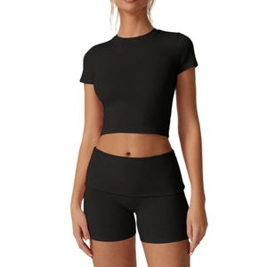 Dettaglio del crop top a costine nero a maniche corte e pantaloncini a vita alta set sport
